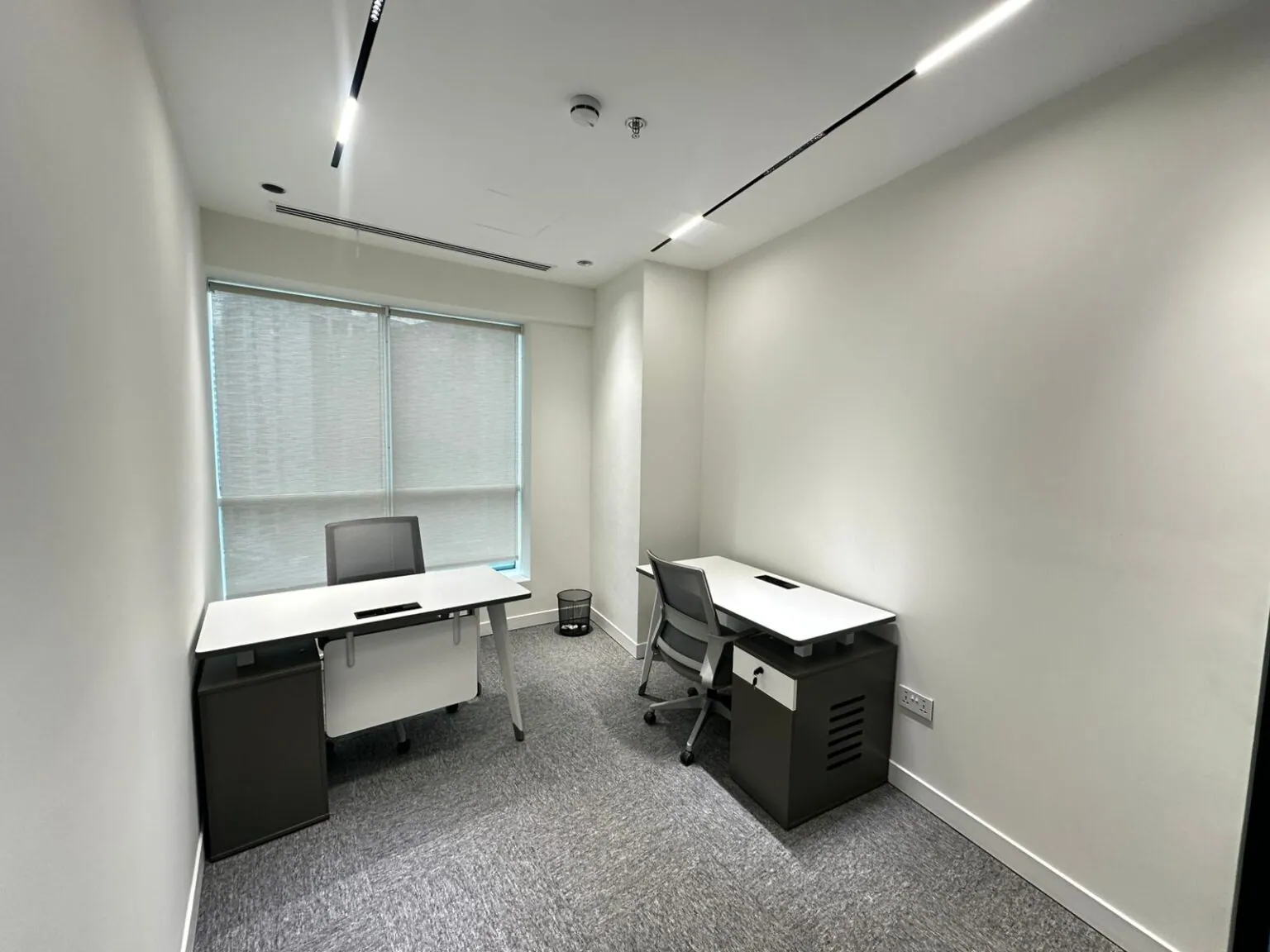A private serviced office at Privé Lounge, with a glass partition and ceiling lighting